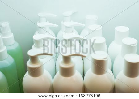 Many white shampoo bottles on store shelf