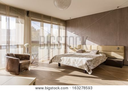 Spacious sunny bedroom interior with marital bed