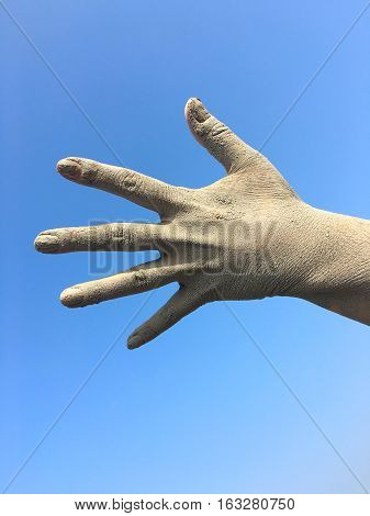 Women's human left hand in the splayed fingers of the hand in the dirt