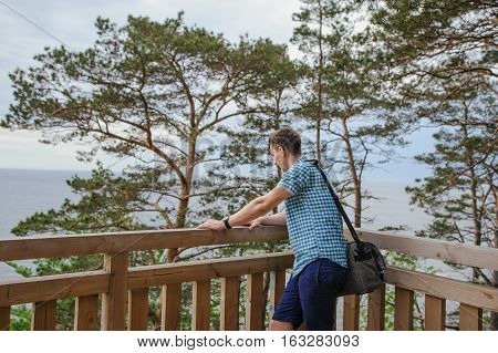 Man Sitting On The Wooden Stairs In Park And Smiling