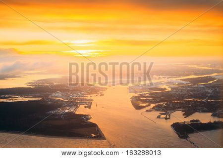 Western Dvina Flows Into The Baltic Sea. River Divides The Northern And Kurzeme District Of Riga, Latvia. View From Airplane Flight. Sunset Sunrise Over Gulf Of Riga, Bay Of Riga, Or Gulf Of Livonia