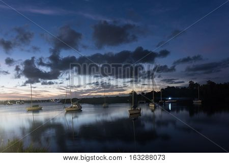 Boats sitting in the lake at sunset in Yamba, Australia