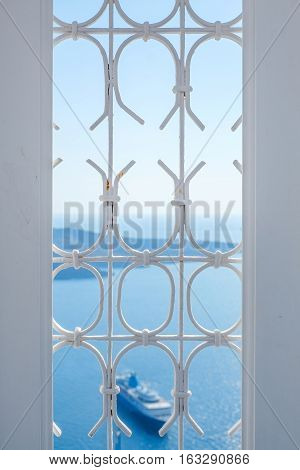 White window and ship in blue sky and sea in Santorini island Oia Greece