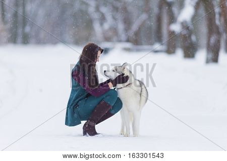 Human and Pet Relationships. Caucasian Brunette Woman Playing with Husky Dog Outdoors in Park Area.Horizontal Image