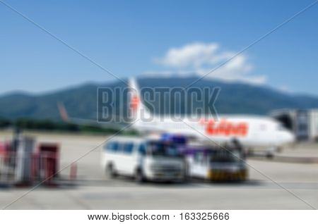 Blur abstract background plane at the airport on loading and ground service. Blurry view airplane parking . Defocused light aircraft land on runway passengers boarding.