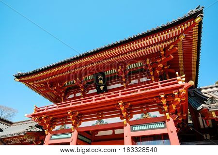 The famous heritage traditional temple Hachiman Shrine with golden red roof against blue sky in Tokyo Japan