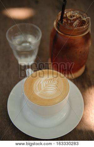 Cup of hot Cappuccino art coffee on wooden table