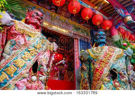 Taiwan - April 30 2016 : God statue in traditional old oriental chinese temple in Taiwan (Chinese Translation on god's strap : mazu temple on couplet : god bless people)