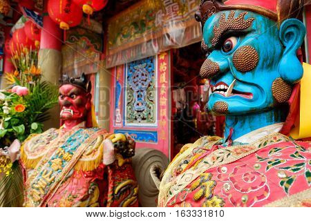 Taiwan - April 30 2016 : God statue in traditional old oriental chinese temple in Taiwan (Chinese Translation on god's strap : mazu temple on couplet : god bless people)