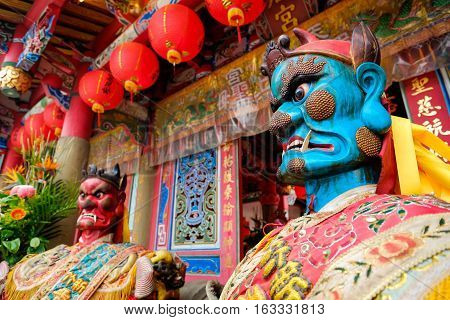 Taiwan - April 30 2016 : God statue in traditional old oriental chinese temple in Taiwan (Chinese Translation on god's strap : mazu temple on couplet : god bless people)