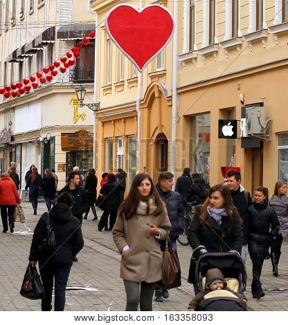 Uzhgorod Ukraine - February 11 2016: Pedestrians walk under a garland of hearts on the eve of Valentine's Day in the city center.