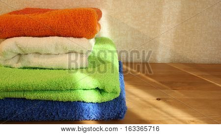 Closeup of four soft colorful towels with some copy space on the right
