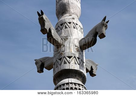A carved wooden totem depicting horses over a cloudy sky, Moscow, Ethnomir park, June 2016