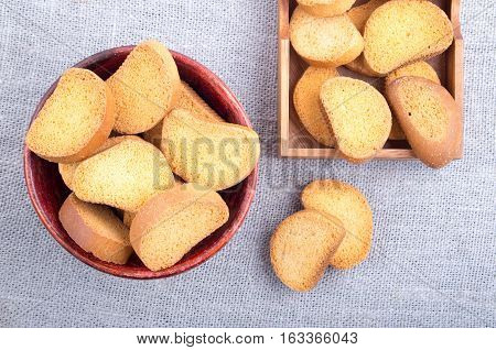 Rusk In The Old Brown Wooden Bowl On A Gray Tablecloth