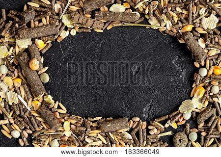 dry food for rodents on dark background top view.