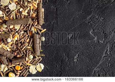dry food for rodents on dark background top view.