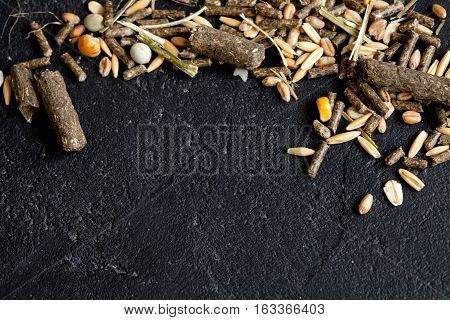 dry food for rodents on dark background top view.