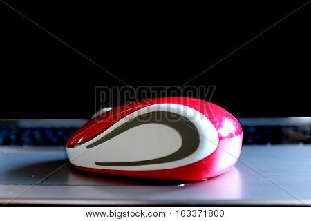 red computer mouse on the black background