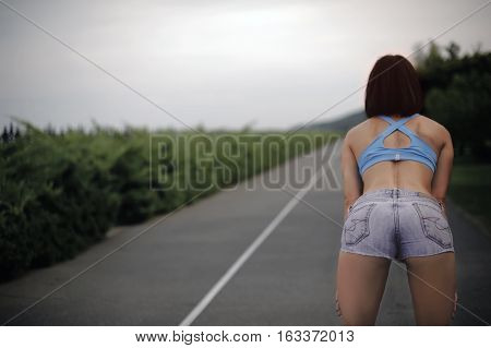 a woman stands hunched before the morning jog