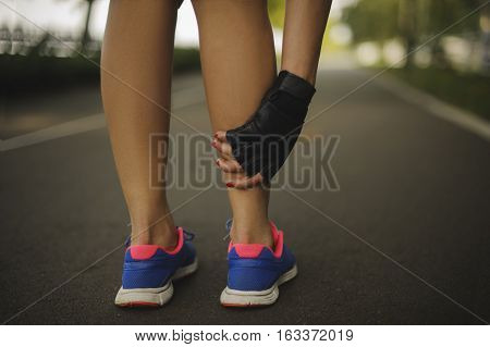 woman massaging legs before the run on the road