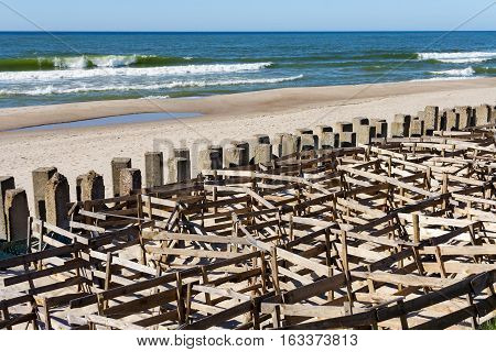 fascine cage made from boards to keep the sand on the beach. Protective structures