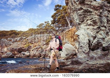 Summer hiking in the mountains with a backpack .