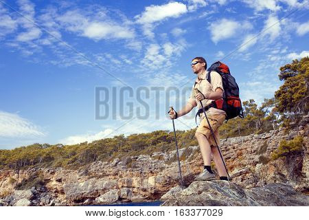Summer hiking in the mountains with a backpack .