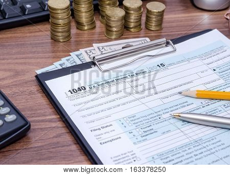 US Federal Income 1040 tax return form with money and pen