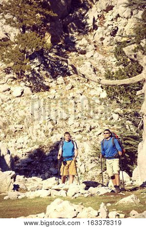 Summer hiking in the mountains with a backpack .