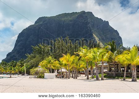 Le Morne Mauritius - December 7 2015: People relax on the Beach at Le Morne Brabant one of the finest beaches in Mauritius. Le Morne Brabant mountain in the background.