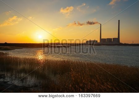 Beautifull landscape with thermal power plant lake and sunset sky.