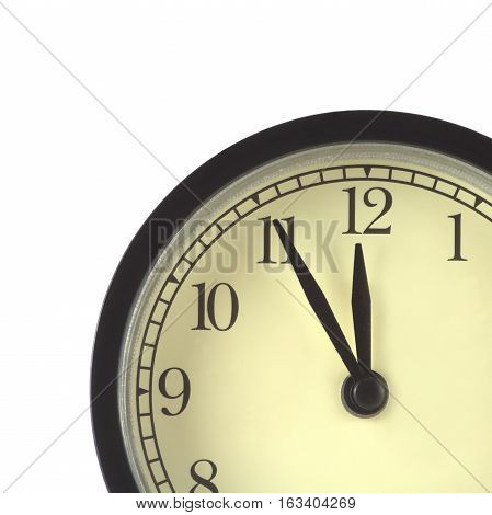 Part of clocks in black case and beige clockface shows 5 minutes to twelve isolated on white close up