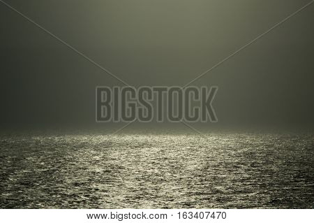 Sparkling water illuminated in the fog by sunshine in the thick foggy morning