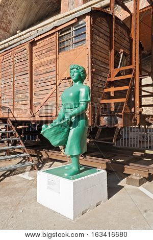 CERBERE, FRANCE-OCTOBER 04, 2016: Green statue in front of an old railroad wagon in Cerbere, France
