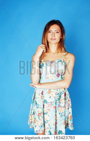 young pretty adorable woman close up like doll posing, natural makeup emotional gesturing on blue background