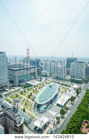 Travel concept - Panoramic modern city bird eye view on Nagoya TV Tower landmark of Nagoya. Oasis21 Aichi art center and holly tree plaza under modern city with blue and sunny morning sky in Japan