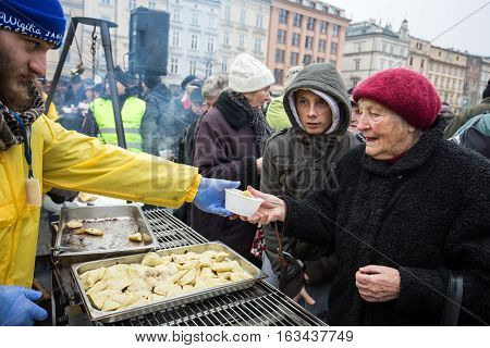 CRACOW POLAND - DECEMBER 18 2016: Christmas Eve for poor and homeless on the Central Market in Cracow. Every year the group Kosciuszko prepares the greatest eve in the open air in Poland