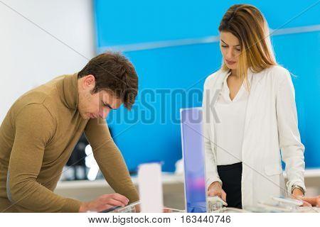 Two people are choosing smart phones in store