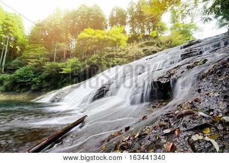 Japan travel concept - beautiful yoro keikoku valley waterfall under dramatic sun glow and morning blue sky in Chiba Prefecture Japan