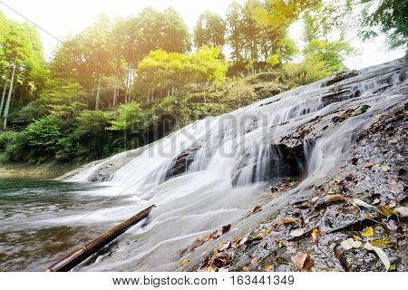 Japan travel concept - beautiful yoro keikoku valley waterfall under dramatic sun glow and morning blue sky in Chiba Prefecture Japan
