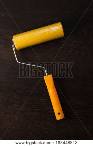 Yellow Paint Roller On A Dark Background
