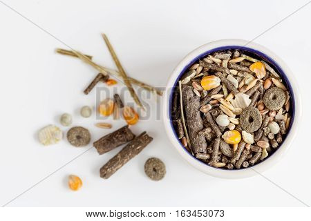 dry food for rodents in bowl on white background top view.