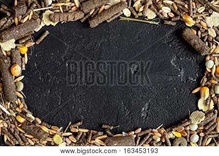dry food for rodents on dark background top view.