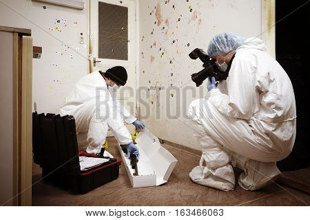 Team of criminologist technicians working on gun packing