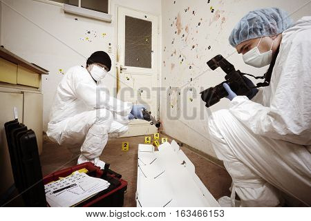 Team of criminologist technicians working on gun packing