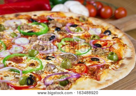 Homemade Tuna Pizza onions, olives, bell pepper on wooden background