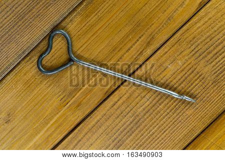 One old gimlet, hand-tools for drilling holes in wood. Brown plywood background