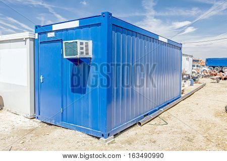 Outdoor unit compressor of air conditioner is placed on container office.
