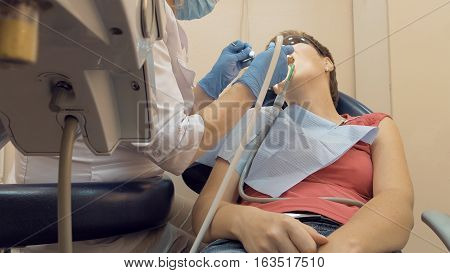 Woman at the dentist clinic office gets dental medical examination and treatment. Odontic and mouth health is important part of modern human life that dentistry help with.