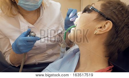 Woman at the dentist clinic office gets dental medical examination and treatment. Odontic and mouth health is important part of modern human life that dentistry help with.